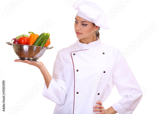 Photo: Portrait of young woman chef with vegetables isolated on white Portrait of young woman chef with vegetables isolated on white