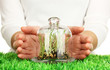 Hands protect grass under glass cover