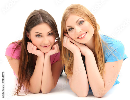 Photo: Two girl friends smiling isolated on white Two girl friends smiling isolated on white
