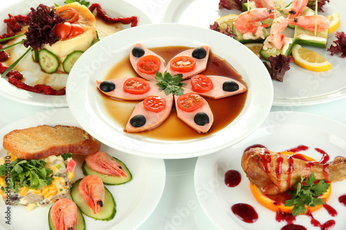 Photo: Small portions of food on big white plates close up Small portions of food on big white plates close up