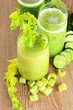 Glasses of green vegetable juice on wooden background