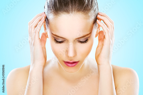 Photo: Beautiful young woman with hands on head, studio shot Beautiful young woman with hands on head, studio shot