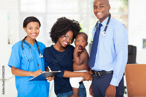 Photo: pediatric medical professionals with mother holding her baby pediatric medical professionals with mother holding her baby
