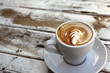 cup of coffee on old wooden table on the beach