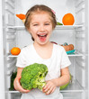 little girl  against a refrigerator