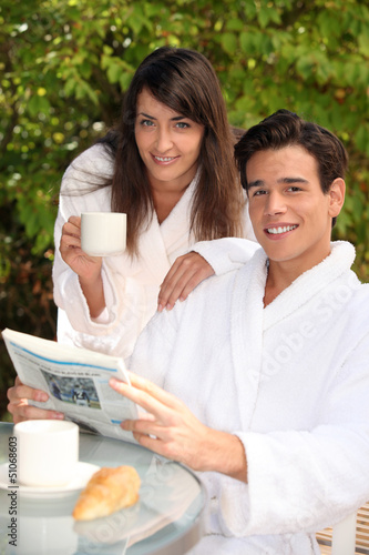 Photo: young couple on vacation having breakfast young couple on vacation having breakfast