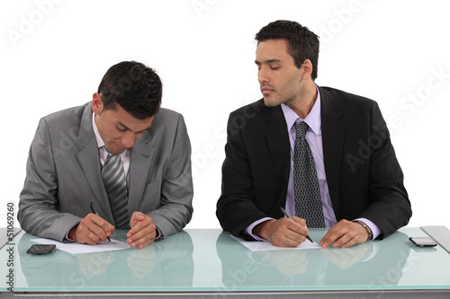 Photo: Businessman cheating in exam Businessman cheating in exam