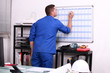 Foto: Factory worker marking date on calendar Factory worker marking date on calendar