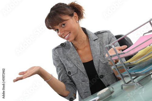Photo: Happy receptionist presenting her work area Happy receptionist presenting her work area