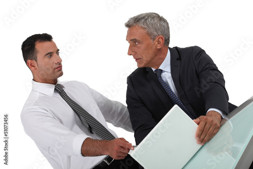 Photo: Serious businessman pointing at a colleague's laptop Serious businessman pointing at a colleague's laptop