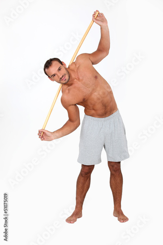Photo: Man exercising with a wooden stick Man exercising with a wooden stick