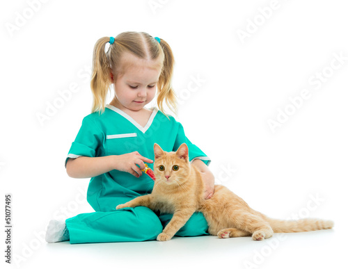 Photo: Cute kid girl playing doctor with cat isolated Cute kid girl playing doctor with cat isolated