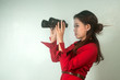 Pretty Asian business woman looking with binoculars .