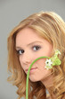 Young woman with flower on gray background