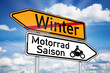Wegweiser mit Winter und Motorradsaison