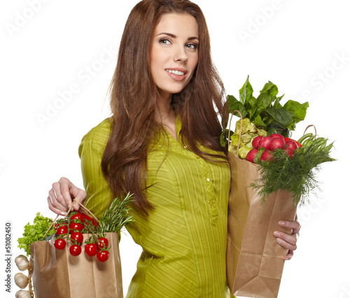 Photo: Portrait of happy young female holding a shopping bag full of gr Portrait of happy young female holding a shopping bag full of gr