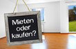 Tafel mit Wohnung im Hintergrund und mieten oder kaufen