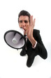 Businessman shouting through megaphone