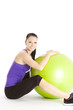 Lachende sportliche Frau mit Gymnastikball