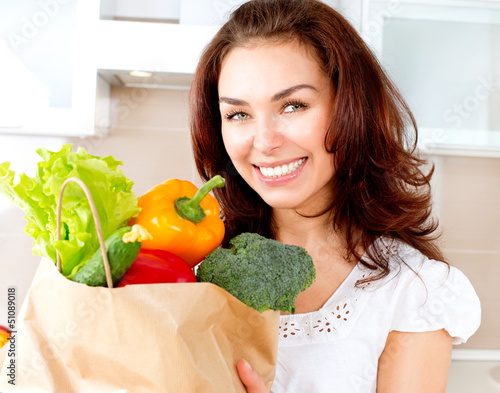 Photo: Happy Young Woman with vegetables in shopping bag. Diet Concept Happy Young Woman with vegetables in shopping bag. Diet Concept
