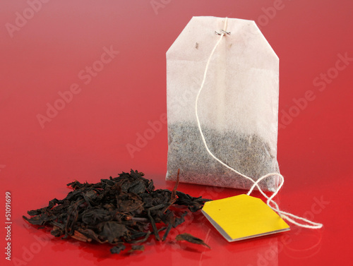 Photo: Tea bag on red background Tea bag on red background