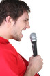 Profile of a man singing into a microphone
