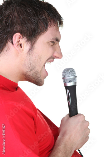 Photo: Profile of a man singing into a microphone Profile of a man singing into a microphone