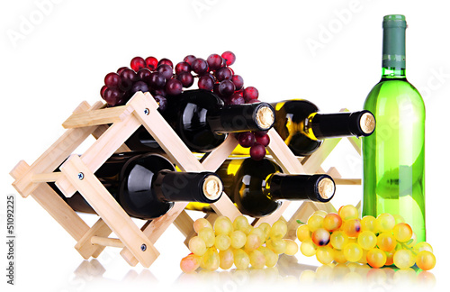 Photo: Bottles of wine placed on wooden stand isolated on white Bottles of wine placed on wooden stand isolated on white