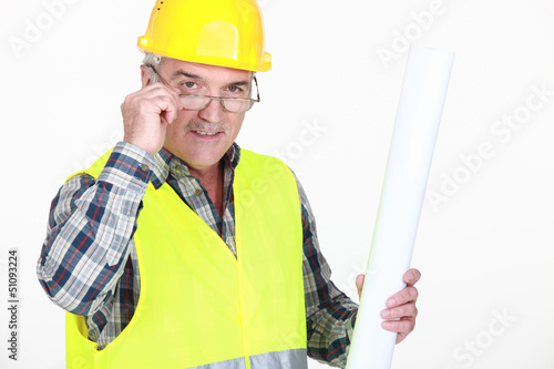 Photo: A mature foreman holding plans. A mature foreman holding plans.