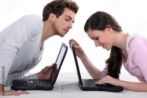 Photo: Man stealing a glance at his neighbour's laptop Man stealing a glance at his neighbour's laptop