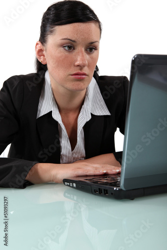 Photo: Bored woman staring at her laptop Bored woman staring at her laptop