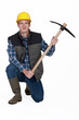Worker kneeling with pick-ax