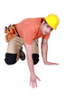 Kneeling tradesman reaching down