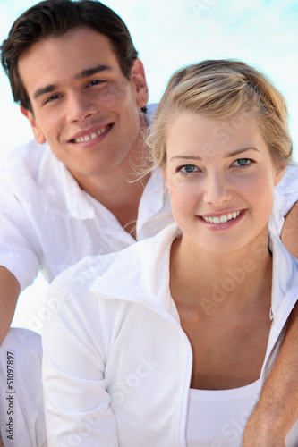 Photo: Smiling young couple dressed in white on a summer's day Smiling young couple dressed in white on a summer's day