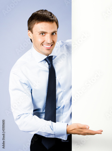 Photo: Business man showing blank signboard, on violet Business man showing blank signboard, on violet