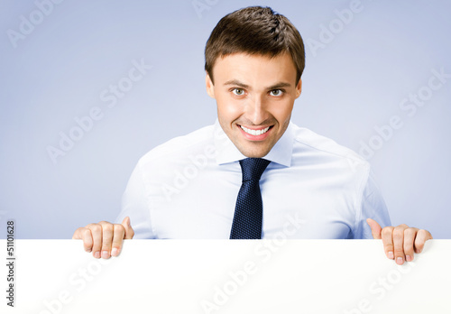 Photo: Business man showing blank signboard, on violet Business man showing blank signboard, on violet