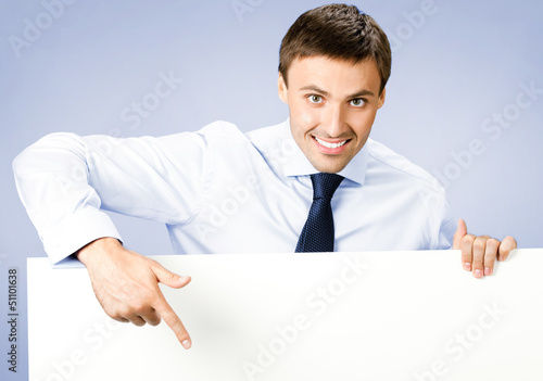 Photo: Business man showing blank signboard, on violet Business man showing blank signboard, on violet