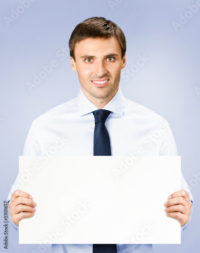 Photo: Business man showing blank signboard, on violet Business man showing blank signboard, on violet