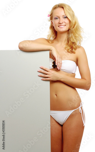 Photo: A young woman in a swimsuit with a blank A young woman in a swimsuit with a blank