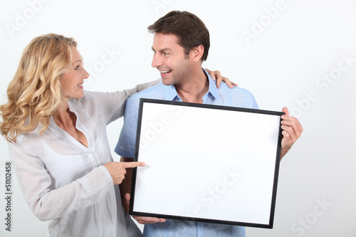 Photo: couple holding a frame couple holding a frame