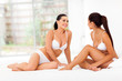 two women friends in underwear sitting on bed