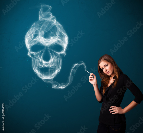 Photo: Young woman smoking dangerous cigarette with toxic skull smoke Young woman smoking dangerous cigarette with toxic skull smoke
