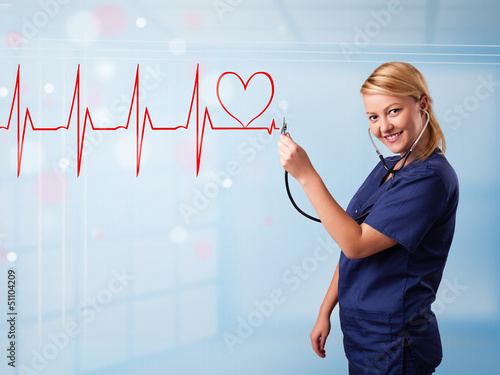 Photo: Young nurse listening to abstract pulse with red heart Young nurse listening to abstract pulse with red heart