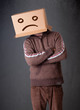Young man with a brown cardboard box on his head with sad face