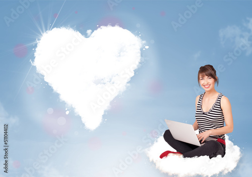 Photo: Beautiful lovely woman sitting on cloud with heart Beautiful lovely woman sitting on cloud with heart