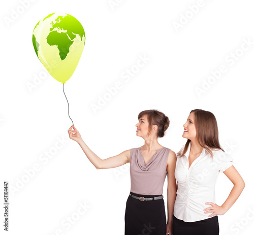 Photo: Happy ladies holding a green globe balloon Happy ladies holding a green globe balloon
