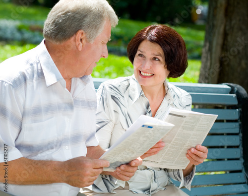 Photo: Happy senior couple reading outdoors Happy senior couple reading outdoors