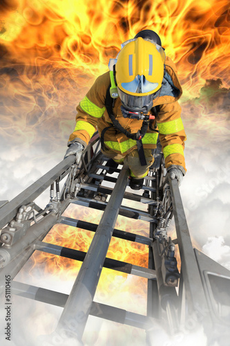 Photo: Firefighter ascends upon a one hundred foot ladder. Firefighter ascends upon a one hundred foot ladder.