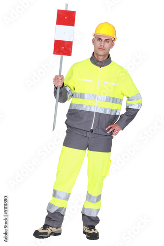 Photo: construction worker in safety outfit holding construction sign construction worker in safety outfit holding construction sign