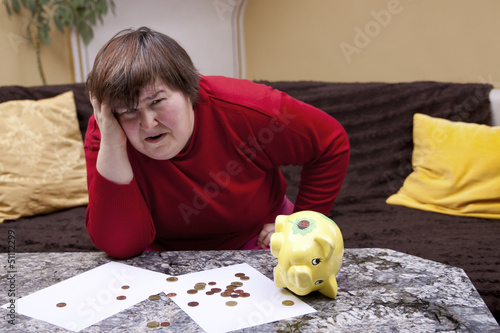 Photo: Behinderte Frau blickt verzweifelt, vor ihr Rechnungen Behinderte Frau blickt verzweifelt, vor ihr Rechnungen